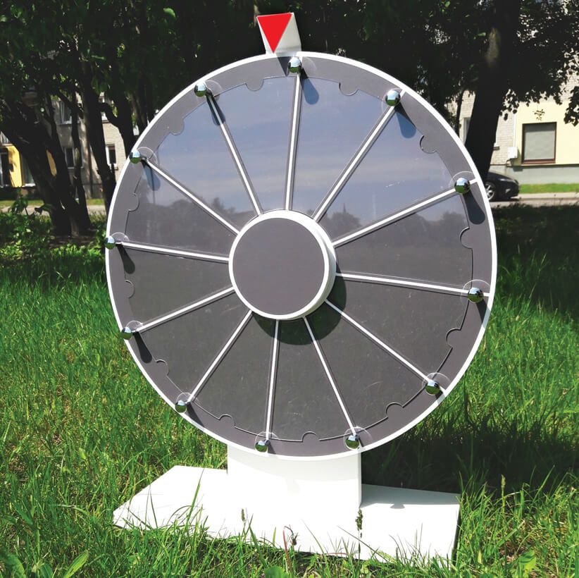 Grey custom prize wheel of fortune on a white stand outdoors