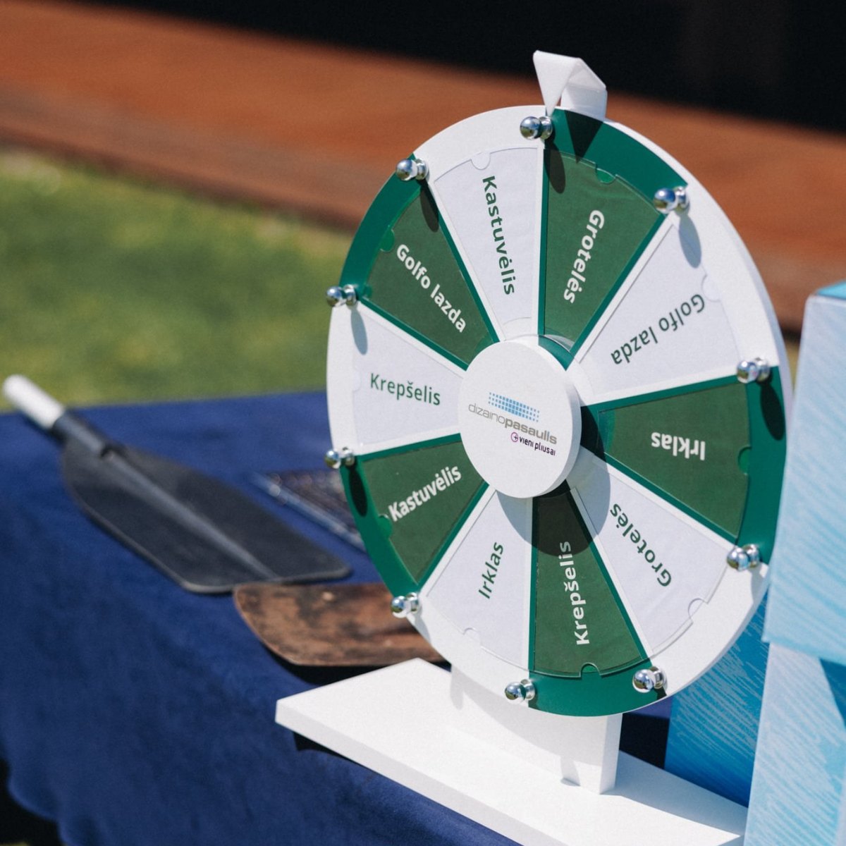 Tabletop prize wheel of fortune with custom logo at an outdoor golf event